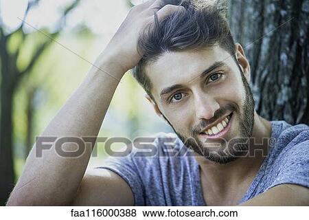 Close-up of smiling young man View Large Photo Image Stock Photo - Close-up of smiling young man. Fotosearch