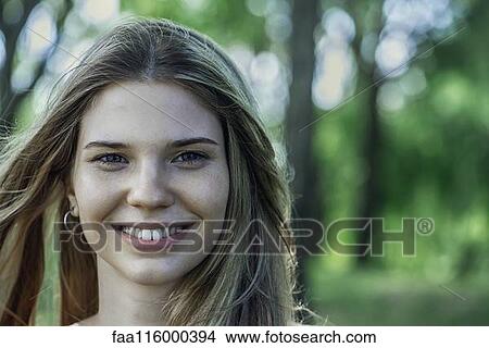 Close-up of smiling young woman View Large Photo Image Picture - Close-up of smiling young woman. Fotosearch