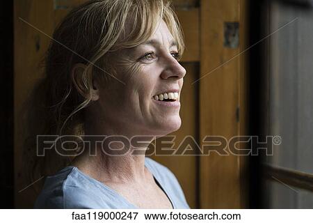 Close-up of thoughtful woman looking through window View Large Photo Image Stock Photo - Close-up of thoughtful woman looking through window. Fotosearch