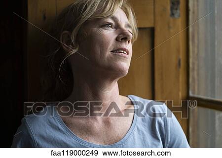 Close-up of thoughtful woman standing near window View Large Photo Image Stock Photo - Close-up of thoughtful woman standing near window. Fotosearch