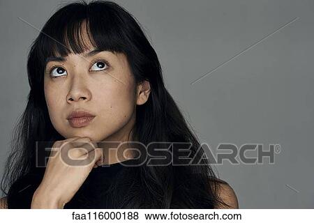 Close-up of thoughtful young woman View Large Photo Image Stock Photo - Close-up of thoughtful young woman. Fotosearch