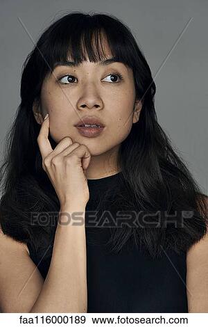 Close-up of thoughtful young woman View Large Photo Image Stock Photo - Close-up of thoughtful young woman. Fotosearch