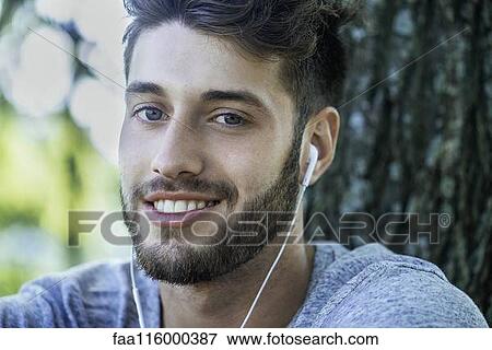 Close-up of young man listening to music View Large Photo Image Stock Photo - Close-up of young man listening to music. Fotosearch