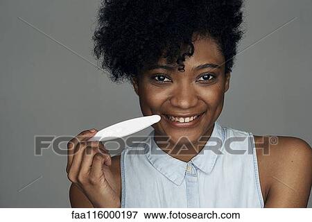 Stock Photo - Close-up of young woman holding pregnancy test strip. Fotosearch