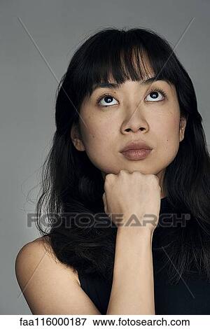 Stock Photo - Close-up of young woman looking up. Fotosearch