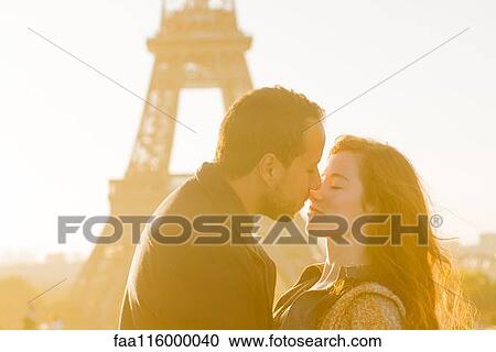 Stock Image - Couple embracing at Eiffel Tower. Fotosearch