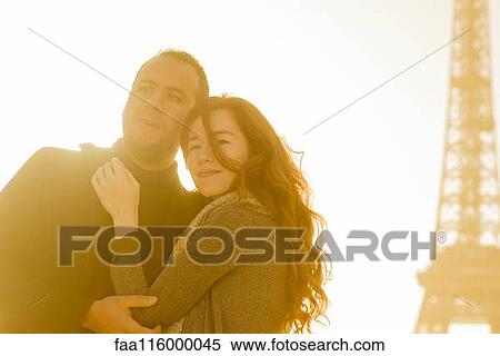 Stock Photography - Couple embracing at Eiffel Tower. Fotosearch