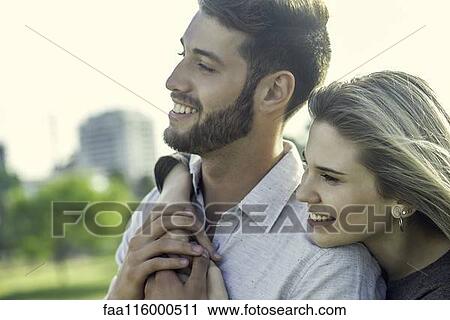 Stock Image - Couple embracing each other in park. Fotosearch