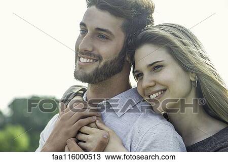 Stock Image - Couple embracing each other in park. Fotosearch