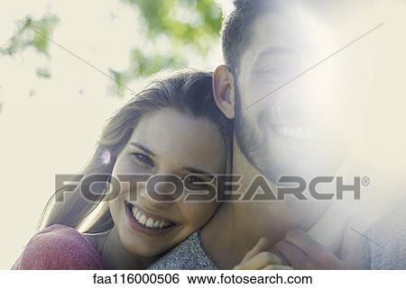 Couple embracing each other in park View Large Photo Image Stock Photograph - Couple embracing each other in park. Fotosearch