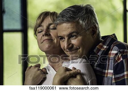 Stock Image - Couple embracing indoors. Fotosearch