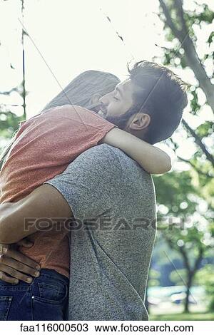 Couple hugging in park View Large Photo Image Stock Image - Couple hugging in park. Fotosearch
