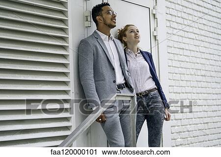 Couple leaning on wall View Large Photo Image Stock Image - Couple leaning on wall. Fotosearch
