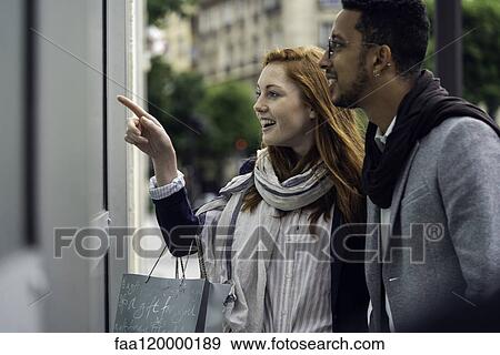 Couple looking at window display View Large Photo Image Stock Photo - Couple looking at window display. Fotosearch