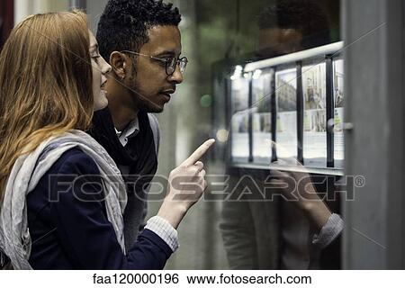 Couple looking at window display View Large Photo Image Stock Photograph - Couple looking at window display. Fotosearch