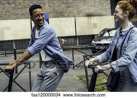 Couple riding push scooters View Large Photo Image Picture - Couple riding push scooters. Fotosearch