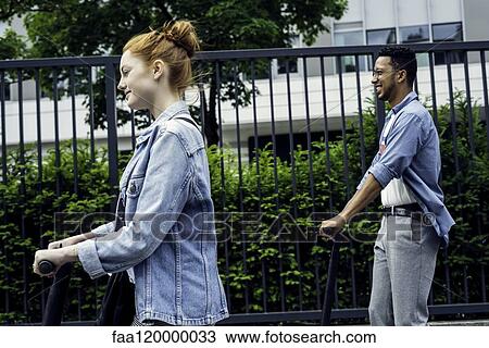 Couple riding push scooters View Large Photo Image Stock Image - Couple riding push scooters. Fotosearch