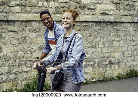 Couple riding push scooters View Large Photo Image Stock Photo - Couple riding push scooters. Fotosearch