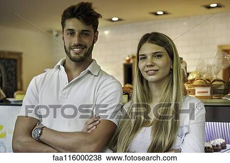 Stock Photo - Couple standing in cake shop. Fotosearch