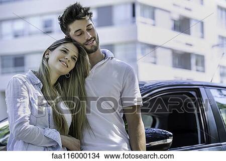 Picture - Couple standing near car. Fotosearch