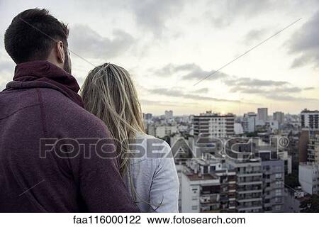 Couple standing on terrace and looking at cityscape View Large Photo Image Stock Image - Couple standing on terrace and looking at cityscape. Fotosearch