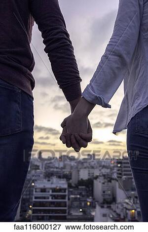 Couple standing on terrace and looking at cityscape View Large Photo Image Stock Photo - Couple standing on terrace and looking at cityscape. Fotosearch