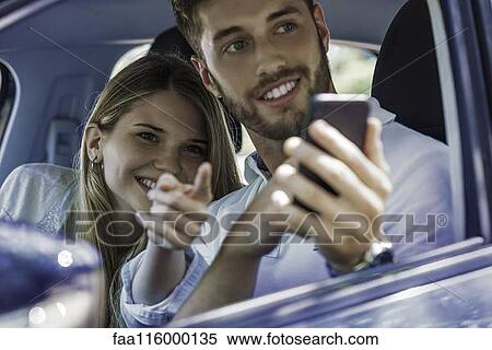 Stock Photography - Couple taking photograph with smartphone. Fotosearch
