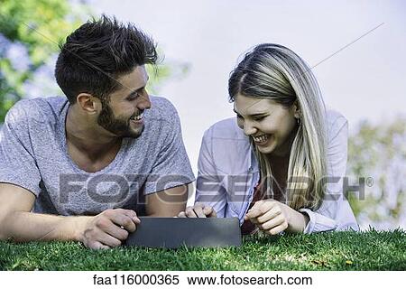 Stock Photography - Couple using digital tablet in park. Fotosearch
