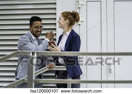 Couple using smart phone outdoors View Large Photo Image Stock Photo - Couple using smart phone outdoors. Fotosearch