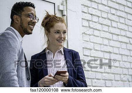 Couple using smart phone outdoors View Large Photo Image Stock Photo - Couple using smart phone outdoors. Fotosearch