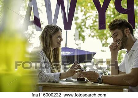 Couple using smartphone in cafe View Large Photo Image Stock Image - Couple using smartphone in cafe. Fotosearch