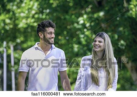 Couple walking together in park View Large Photo Image Stock Image - Couple walking together in park. Fotosearch