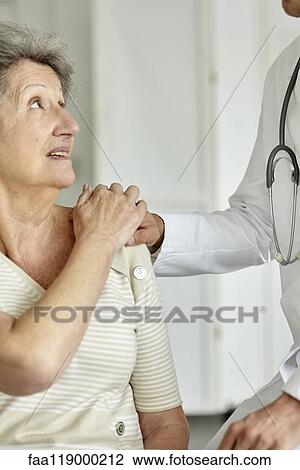 Doctor consoling senior woman View Large Photo Image Stock Image - Doctor consoling senior woman. Fotosearch