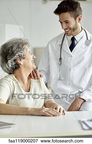 Doctor consoling senior woman View Large Photo Image Stock Photo - Doctor consoling senior woman. Fotosearch