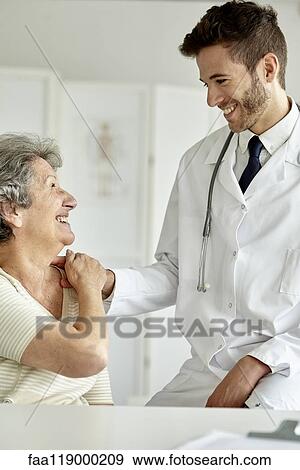 Doctor consoling senior woman View Large Photo Image Stock Photo - Doctor consoling senior woman. Fotosearch