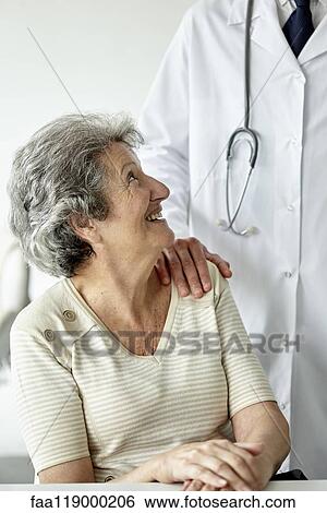 Doctor consoling senior woman View Large Photo Image Stock Photograph - Doctor consoling senior woman. Fotosearch