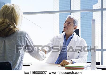 Stock Photo - Doctor shaking hand with patient in clinic. Fotosearch