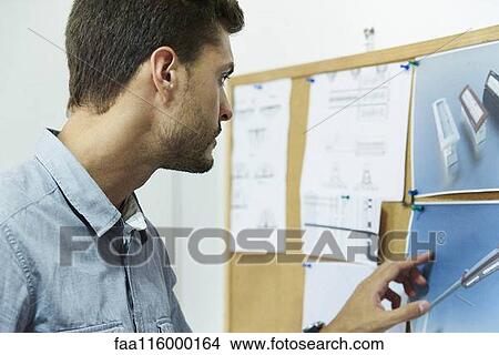 Engineer looking at notice board View Large Photo Image Picture - Engineer looking at notice board. Fotosearch