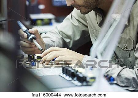 Engineer soldering circuit board in office View Large Photo Image Picture - Engineer soldering circuit board in office. Fotosearch