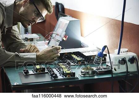 Engineer soldering circuit board in office View Large Photo Image Stock Photo - Engineer soldering circuit board in office. Fotosearch