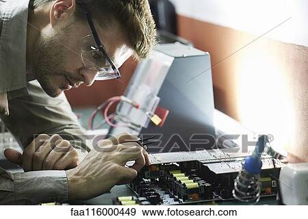 Engineer soldering circuit board in office View Large Photo Image Stock Photo - Engineer soldering circuit board in office. Fotosearch