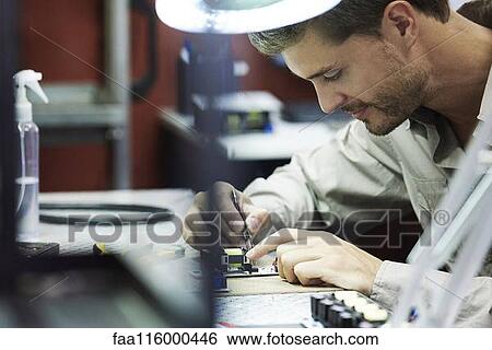 Engineer soldering circuit board in office View Large Photo Image Stock Photograph - Engineer soldering circuit board in office. Fotosearch
