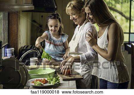 Stock Photo - Family preparing food in kitchen. Fotosearch