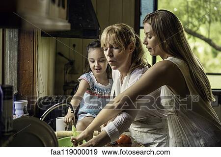 Family preparing food in kitchen View Large Photo Image Stock Photo - Family preparing food in kitchen. Fotosearch
