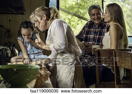 Stock Image - Family talking in kitchen. Fotosearch