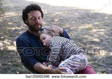 Father and daughter sitting in park View Large Photo Image Stock Photograph - Father and daughter sitting in park. Fotosearch