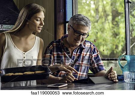 Stock Image - Father and daughter using digital tablet. Fotosearch