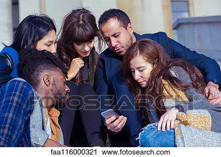 Friends sitting on steps and using smartphone View Large Photo Image Stock Image - Friends sitting on steps and using smartphone. Fotosearch