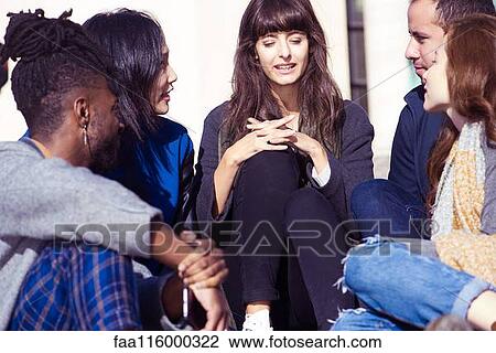 Stock Image - Friends sitting together on steps. Fotosearch