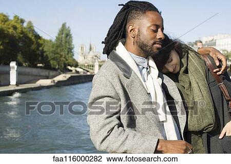 Stock Image - Friends standing together in boat. Fotosearch